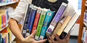 a student juggling an armload of library books