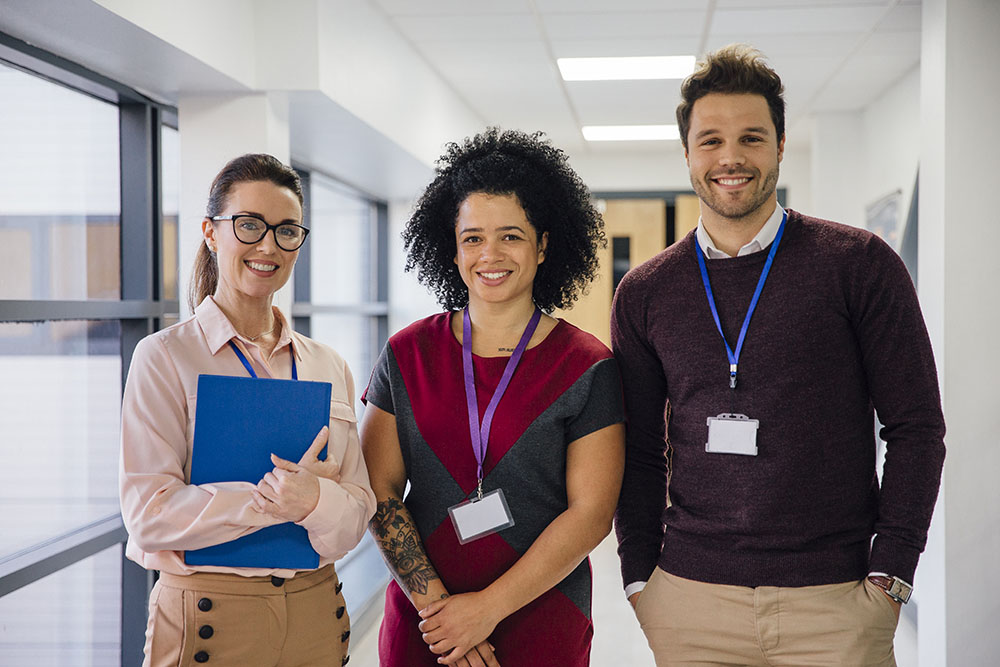 Portrait of three teachers in the school hall.